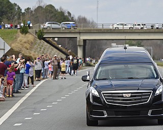 People watch as the hearse carrying the body of Billy Graham drives toward the Billy Graham Library in Cherryville, N.C., Saturday, Feb. 24, 2018. Graham's body was brought to his hometown of Charlotte on Saturday, Feb. 24, as part of a procession expected to draw crowds of well-wishers. (AP Photo/Kathy Kmonicek, Pool)