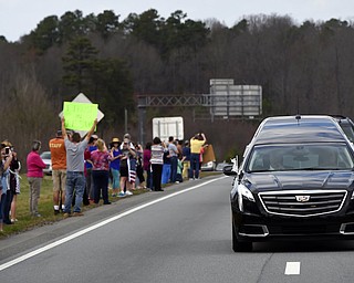 People watch as the hearse carrying the body of Billy Graham near Hickory, N.C., as it drives toward the Billy Graham Library Saturday, Feb. 24, 2018. Graham's body was brought to his hometown of Charlotte on Saturday, Feb. 24, as part of a procession expected to draw crowds of well-wishers. (AP Photo/Kathy Kmonicek, Pool)