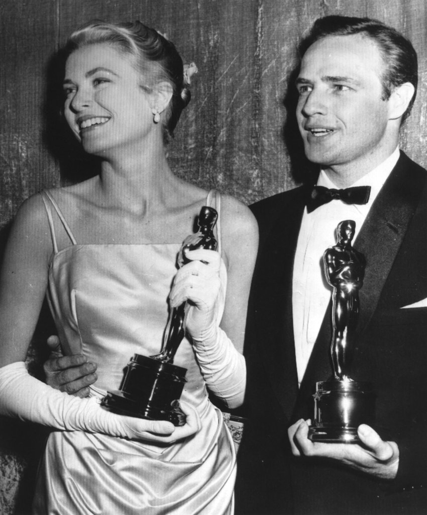 FILE - In this March 31, 1955 file photo, Grace Kelly, left, and Marlon Brando, hold their best actress and actor Oscars in Los Angeles. Kelly's icy green satin gown was designed by Edith Head.  (AP Photo, File)