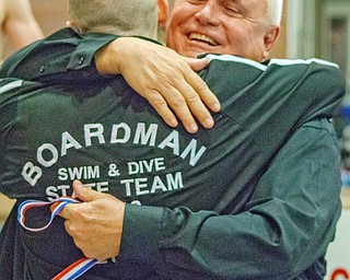 Boardman swimming coach Terry O’Halloran hugs senior Callen Aulizia following Saturday’s 400-yard freestyle relay at the Division I Ohio State Swimming and Diving Championships at 
C.T. Branin Natatorium in Canton. O’Halloran, who is retiring after 33 years as the Spartans coach, was named the Division I Coach of the Year.