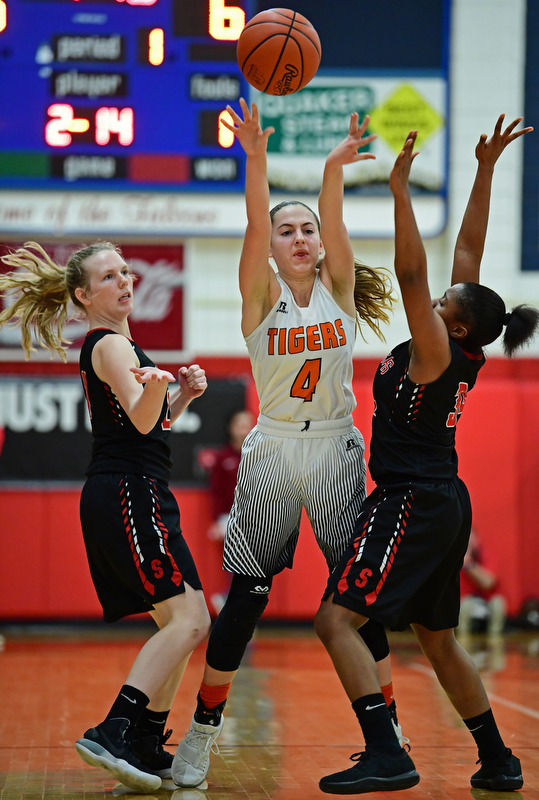 AUSTINTOWN, OHIO - FEBRUARY 26, 2018: Howland's Mackenzie Maze passes the ball while being pressured by Struthers' Keasia Chism, right, and Renee Leonard during the first half of their OHSAA district tournament game at Fitch High School. Howland won 35-24. DAVID DERMER | THE VINDICATOR