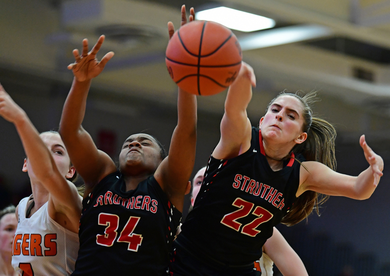 AUSTINTOWN, OHIO - FEBRUARY 26, 2018: Struthers' Michelle Buser, right, Keasia Chism and Howland's Mackenzie Maze fight for a rebound during the second half of their OHSAA district tournament game at Fitch High School. Howland won 35-24. DAVID DERMER | THE VINDICATOR