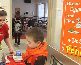 First-grader Jacob Zick of Austintown Elementary School gets his breakfast, including the classic green eggs and ham, from cafeteria worker Julie Carson during the Dr. Seuss birthday event Friday.