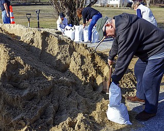 John Woodland fills a sandbag to use at his home, Thursday, March 1, 2018, in Scituate, Mass., ahead of Friday's expected storm, predicted to bring high winds and the potential for coastal flooding. (Greg Derr/The Quincy Patriot Ledger via AP)