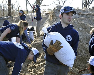 AmeriCorps worker Conor Terry lugs sandbags to a storage area at the town's DPW facility as preparations are underway for the approaching storm, Thursday, March 1, 2018 in Provincetown, Mass. (Steve Heaslip/The Cape Cod Times via AP)