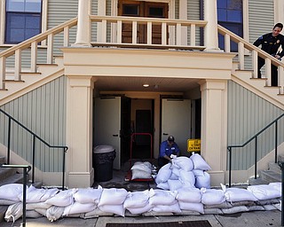 Provincetown DPW worker Paulo Andrade moves sand bags around the lower entrance to town hall as preparations are underway for the approaching storm, Thursday, March 1, 2018 in Provincetown, Mass. (Steve Heaslip/The Cape Cod Times via AP)