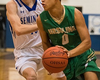 Ursuline's Devan Keevey dribbles past Poland's Dan Kramer during first quarter action of sectional tournament action at Poland on Friday. Poland won 68-47...Photo by Dianna Oatridge