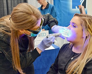 Sheila Johnston gives Nicole Bodnar a free oral cancer screening at the Valley Health and Wellness Expo held a Covelli Centre on Saturday March 3, 2018. Braydich Dental, who was offering the free screening, also gave away more than 700 toothbrushes at the event...Photo by Scott Williams, The Vindicator.