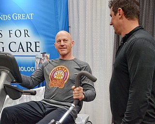 Jason Pridon from Muscle Connection talks with Paul Minotti who is trying out a Cardio Strider at the Valley Health and Wellness Expo at the Covelli Centre on Saturday, March 3, 2018...Photo by Scott Williams, The Vindicator.