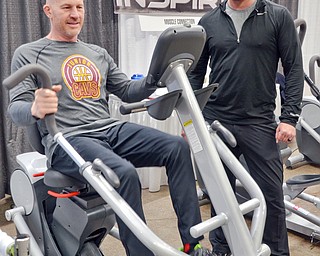 Jason Pridon, right, from Muscle Connection talks with Paul Minotti who is trying out a Cardio Strider at the Valley Health and Wellness Expo at the Covelli Centre on Saturday, March 3, 2018...Photo by Scott Williams, The Vindicator.