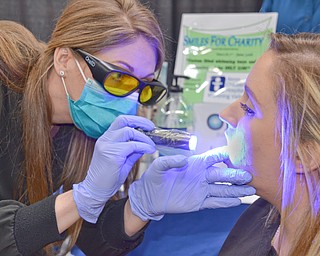 Sheila Johnston gives Nicole Bodnar a free oral cancer screening at the Valley Health and Wellness Expo held a Covelli Centre on Saturday March 3, 2018. Braydich Dental, who was offering the free screening, also gave away more than 700 toothbrushes at the event...Photo by Scott Williams, The Vindicator.