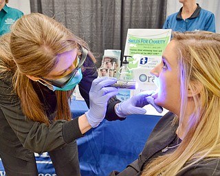 Sheila Johnston gives Nicole Bodnar a free oral cancer screening at the Valley Health and Wellness Expo held a Covelli Centre on Saturday March 3, 2018. Braydich Dental, who was offering the free screening, also gave away more than 700 toothbrushes at the event...Photo by Scott Williams, The Vindicator.