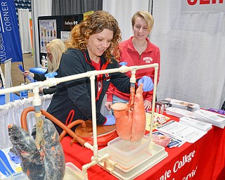 Tammy Kemble, left, pumps air into two lungs, one representing a smoker's lungs and the other representing clean lungs, as Kristina Ritch observes. Both ladies are respiratory care majors at Youngstown State University and were volunteering at the Bitonte College of Health and Human Services table at the Valley Health and Wellness Expo, held at Covelli Center on Saturday, March 3, 2018...Photo by Scott Williams, The Vindicator.