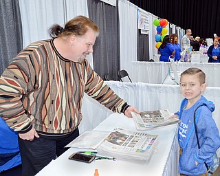 John Borzea hands 7 year old Tommy Zimmerlee a copy of SaturdayÕs edition of The Vindicator at the Valley Health and Wellness Expo held at Covelli Centre on Saturday March 3, 2018. The Vindicator was a sponsor of the event...photo by Scott Williams, The Vindicator..