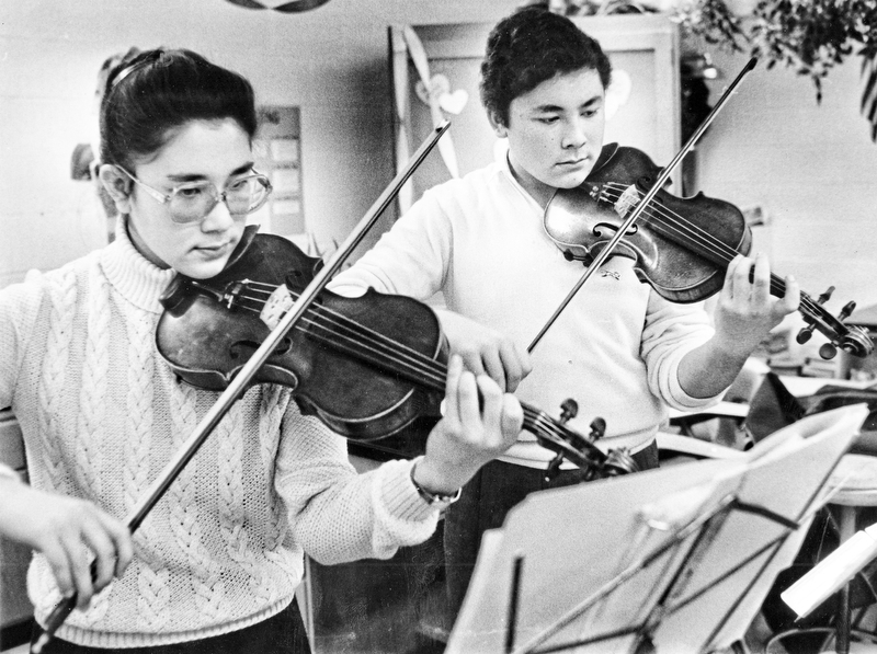 The last rehearsal: Brother and sister duet Maria (12th grade) and Paul (11th grade) Watanakunakorn of Boardman High School practice on their violins Saturday at Canfield High School prior to playing in a music competition sponsored by District V of the Ohio Music Educators Association.  More than 1,200 high school students participated in competitions at both Canfield and Frank Ohl Middle School, Austintown. ..This photo first ran in The Vindicator on Sunday, February 8, 1987...Photo by William D. Lewis, The Vindicator.