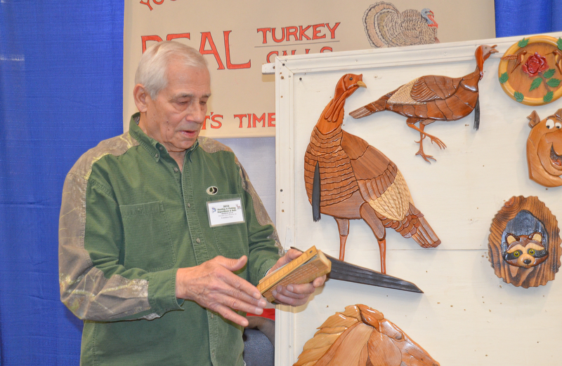 Jim Pasquale, from Howland, Ohio, demonstrates one of his hand made turkey calls at The Sportsman's Hunting and Fishing Supershow and Sale at the Metroplex Expo Center in Girard, Ohio on Sunday March 4, 2018.  Pasquale has hand carved turkey calls and wall decorations for nearly twenty-five years since his retirement. ..Photo by Scott Williams - The Vindicator.