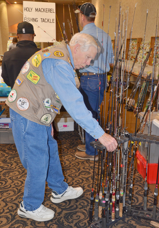 Mike Wohlever, from Amherst, Ohio, tends to his fishing poles set up at his booth at The Sportsman's Hunting and Fishing Supershow and Sale at the Metroplex Expo Center in Girard, Ohio on Sunday, March 4, 2018.  Wohlever hosts the Holy Mackerel flea market in Oberlin, Ohio in April...Photo by Scott Williams - The Vindicator.