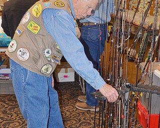 Mike Wohlever, from Amherst, Ohio, tends to his fishing poles set up at his booth at The Sportsman's Hunting and Fishing Supershow and Sale at the Metroplex Expo Center in Girard, Ohio on Sunday, March 4, 2018.  Wohlever hosts the Holy Mackerel flea market in Oberlin, Ohio in April...Photo by Scott Williams - The Vindicator.