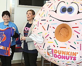 Laura Elder, left, Thomasina Dennison and the Dunkin’ Donuts mascot display one of the 180 superhero-themed hospital gowns that were given to patients at Akron Children’s Hospital Mahoning Valley in Boardman on Tuesday for the “Day of Joy.”
