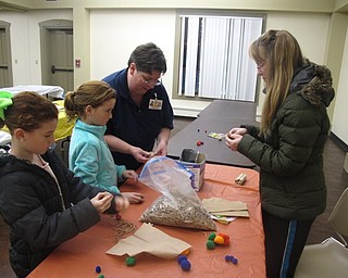 Neighbors | Zack Shively.Children at the Boardman library visited the meeting room for a story time and a chance to make crafts. Pictured, the children and their mother, with the assistance of Boardman librarian Karen Saunders created a ball made of rubber bands to play jacks.
