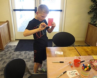 Neighbors | Zack Shively.The Wizard of Oz Valentine's Celebration at the Austintown library offered a station where the children could make Valentine's Day cards using crafting materials. Pictured, Camden Cox used a hole punch to decorate his Valentine's Day card.