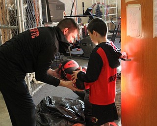 Neighbors | Abby Slanker.Canfield High School varsity basketball head coach Todd Muckleroy distributed youth basketballs to youth players who participated in the first season of the Courtside Cardinals at the courtside open house.