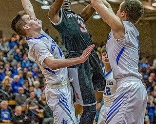 Struthers' Kevin Traylor drives to the basket between Lakeview defenders TJ Lynch (L) and Daniel Evans (R) during Lakeview's 72-59 win for the Division II District Championship in Boardman on Saturday...Photo by Dianna Oatridge.