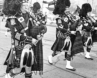 The MacCallum Highlanders Pipe and Drums of Akron march past green-tinted snowbanks on Route 224 during the sixth annual St. Patrick's Day Parade, held for the first time in Boardman...Photo taken on March 11, 1984...Photo by Robert K. Yosay - The Vindicator.