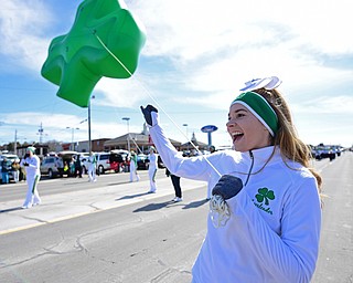 BOARDMAN, OHIO - MARCH 11, 2018: Ursuline cheerleader Liz Chrobak pumps her first while walking with the giant shamrock inflatable while marching on Market Street during the Mahoning Valley St. Patrick's Day Parade. DAVID DERMER | THE VINDICATOR