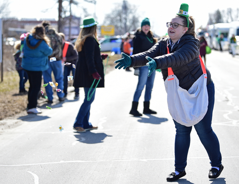 BOARDMAN, OHIO - MARCH 11, 2018: Vindicator reporter Amanda Tonoli throws out some candy while marching on Market Street during the Mahoning Valley St. Patrick's Day Parade. DAVID DERMER | THE VINDICATOR