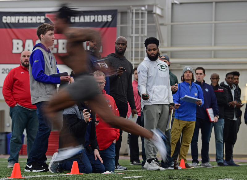YOUNGSTOWN, OHIO - MARCH 13, 2018: Scouts from different NFL and CFL teams watch as Youngstown State's Damoun Patterson sprints through the finish line during the 40 yard dash during the Youngstown State football pro day, Tuesday morning at the Watts Indoor Facility. DAVID DERMER | THE VINDICATOR