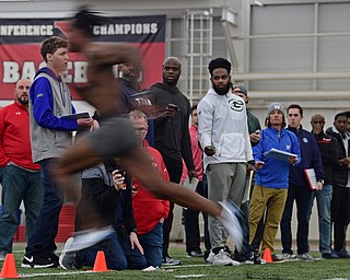 YOUNGSTOWN, OHIO - MARCH 13, 2018: Scouts from different NFL and CFL teams watch as Youngstown State's Damoun Patterson sprints through the finish line during the 40 yard dash during the Youngstown State football pro day, Tuesday morning at the Watts Indoor Facility. DAVID DERMER | THE VINDICATOR