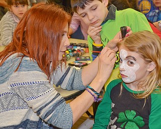 Maria Rosensteel, a 7th grade teacher at Campbell, paints a face on Abby Lencyk, 2nd grade student at South Range, as Oliver Ruediger, 2nd grade student at Campbell, waits his turn at Campbell Community Night at Campbell K-7 School on Thursday, March 15, 2018...Photo by Scott Williams - The Vindicator.