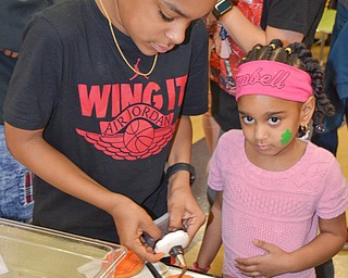 Jabari Rushton, left; 7th grade, helps his sister Serenity Cunningham, right; kindergarten, decorate some basketball cookies at Campbell Community Night at Campbell K-7 School on Thursday, March 15, 2018...Photo by Scott Williams - The Vindicator.