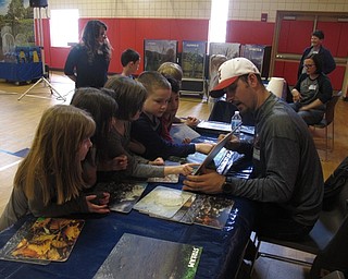 Neighbors | Zack Shively.The Austintown Elementary School's PTA brought COSI to the school to give the students a taste of science education. The PTA also ran the activity stations where children learned about ecology. Pictured, the students look at pictures of different habitats throughout the seasons.
