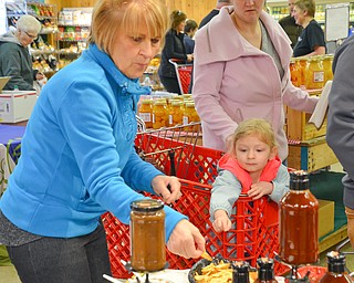 Debbie Bacorn, from Champion, and her granddaughter, Nathalee Bacorn, age 4, of Lake Milton, reach for a sample of White House BBQ Sauce at the 16th Annual White House Weekend at White House Fruit Farm in Canfield on Saturday, March 17, 2018...Photo by Scott Williams - The Vindicator.