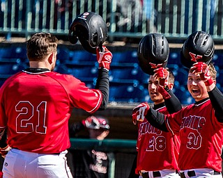 THE VINDICATOR | DIANNA OATRIDGE..Youngstown State players Zach Lopatka (28) and Drew Dickerson (30) lift up their helmets in celebration of teammate Andrew Kendrick's (21) three-run homer during their game against Milwaukee on Saturday at Eastwood Field.