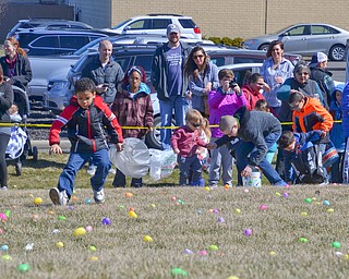 Juwan Ditosto, age 6, in the black and red jacket, runs ahead of the compeition to grab his eggs at Rulli Brothers in Boardman on Sunday March 18, 2018.  His mother, Jessica Bell, of Youngstown, is over his shoulder watching...Photo by Scott Williams - The Vindicator