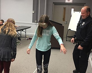 Neighbors | Submitted .At the Too Good For Drugs Program, fifth-grader Brenyn Wilson tries to walk a straight line with Fatal Vision Goggles, as school resource officer Mike Salser stands by for guidance.