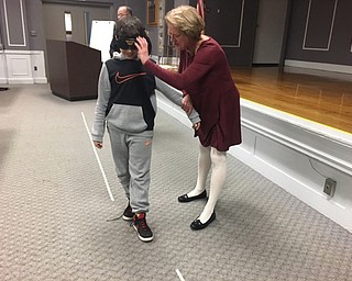 Neighbors | Submitted .Drug educator Karen Kannal is pictured adjusting goggles for a fifth-grader trying to navigate a straight line.