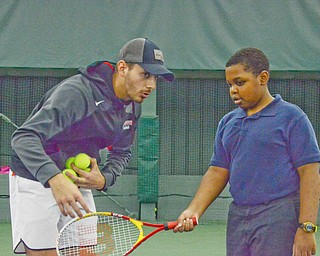 Vasileios Vardakis, YSU freshman business major from Greece, gives Amyre Milender, age 10, some pointers at the Boardman Tennis Center on March 23, 2018.  

Photo by Scott Williams - The Vindicator