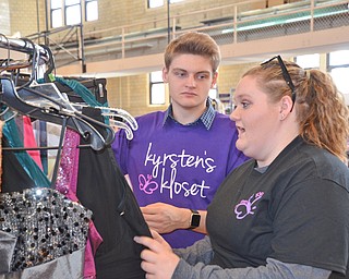 Devin Lewis, age 18, from Hubbard, a volunteer, helps Taylor Pegg, age 17, from Hubbard, look through dresses at the Kyrsten's Kloset event at Roosevelt Elementary School in Hubbard, Ohio on March 24, 2018.

Photo by Scott Williams - The Vindicator