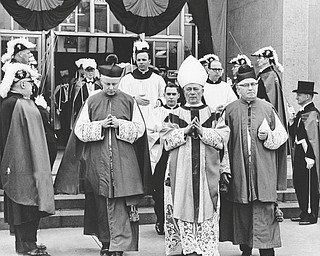 The Most Rev. Carl J. Alter, archbishop of Cincinnati, principal concelebrant of the white pontifical funeral Mass, is flanked by the Rt. Rev. Msgr. John J. Lettau (left), pastor of St. Edward Church and former chancellor for Bishop Walsh, and the Rt. Rev. Msgr. Owen L. Gallagher, V.D., P.A., vicar delegate and pastor of St. John Church, Canton, as he leaves the cathedral after the Mass.  Fourth Degree Knights of Columbus are guards of honor.

Photo taken March 23, 1968.

Photo by Paul R. Schell.