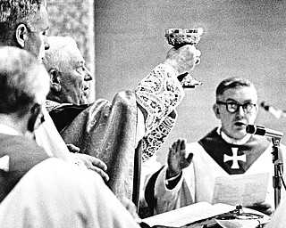 The "Chalice of Salvation" is raised during the consecration of the funeral Mass by Archbishop Alter.  Bishop Malone is at right and Msgr. Lettau at left.

Photo taken March 23, 1968.

Photo by Paul R. Schell.