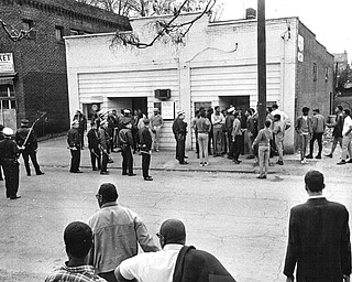 Police confront a group in front of Mac's Tavern at 720 Hillman St., just three doors from the shooting scene.  Police said it took them half an hour to get the group to move this far.