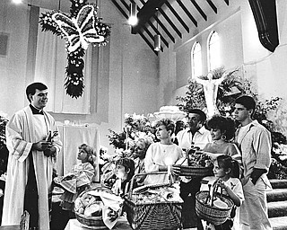 BLESS THESE BASKETS: After the long Lenten season, Catholics are celebrating the Resurrection with a feast.  The Rev. Michael Swierz of St. Rose Church, Girard, conducted the traditional blessing of Easter baskets Saturday.  Parishioners are, from left, Kim Nemkovich, and Jessica and Marilyn Brocious, all of Girard; the Palen Family of Niles, Marge, Ray, Denise, and Bryan; and Julia Bigowsky (foreground) of Girard...Photo by Robert K. Yosay - The Vindicator