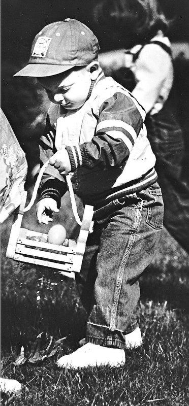 FOUND ONE: Two-year-old Zachary Albright, a son of Roy and Jane Albright of Niles, stashed an Easter egg into his wooden basket during an Easter egg hunt Saturday at the First United Methodist Church in Niles...Photo by Robert K. Yosay - The Vindicator