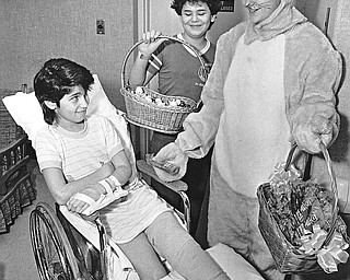 "CANDY" CALLING - The Gorant Candies/Yum Yum Tree Easter Bunny (she is actually Donna Janesh) visited patients Tuesday at St. Elizabeth Hospital Medical Center.  Rebecca Pitts, 10, cast a skeptical glance at the "imposter" while Tony Traficant, 12, was all smiles.  

Photo from March 26, 1986.  

Photo by William D. Lewis - The Vindicator