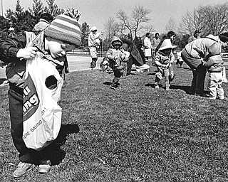 EASTER BUNNY, GOODIES HIGHLIGHT FESTIVITIES - JACYEES HOST ANNUAL EGG HUNT - The resurrection of Jesus Christ is the traditional focus of Easter, but, after that, the most prominent features of the holiday are the Easter bunny and the eggs and candy that he brings.  In keeping with the second half of Easter's significance, the Jaycees on Saturday held their annual Easter egg hunt in the Wick Recreation Area of Mill Creek Park.  Bright, sunny and blue skies accommodated the event although there was a chill in the air and winter clothes were stylish. Christopher Sopkovich, 3, son of Mr. and Mrs. John Sopkovich of Girard, displays his price and his hunting technique. Because he won a coupon, the toddler won the giant Easter basket, containing multiple goodies.

Photo from March 23, 1986.

Photo by William D. Lewis - The Vindicator