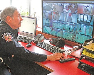 School Resource Officer Ron DeAmicis watches a security monitor at Austintown Fitch High School. Several Mahoning Valley schools are reviewing and updating security protocols in response to the fatal shootings at a high school in Florida in February.